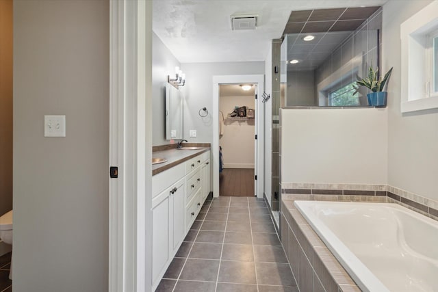 bathroom with tile patterned flooring, vanity, and separate shower and tub