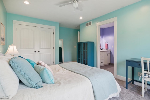 carpeted bedroom featuring ensuite bath, ceiling fan, and a closet