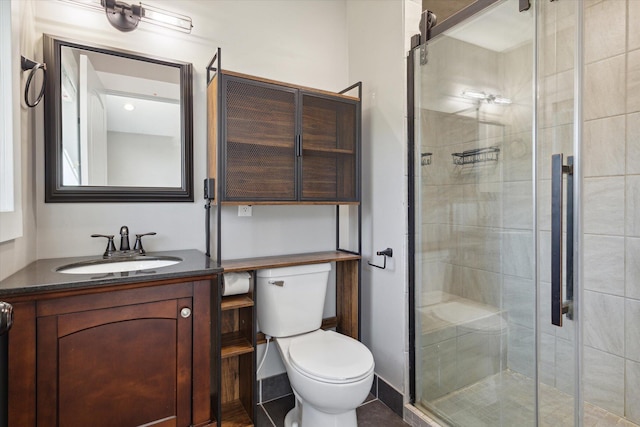 bathroom featuring vanity, toilet, and an enclosed shower