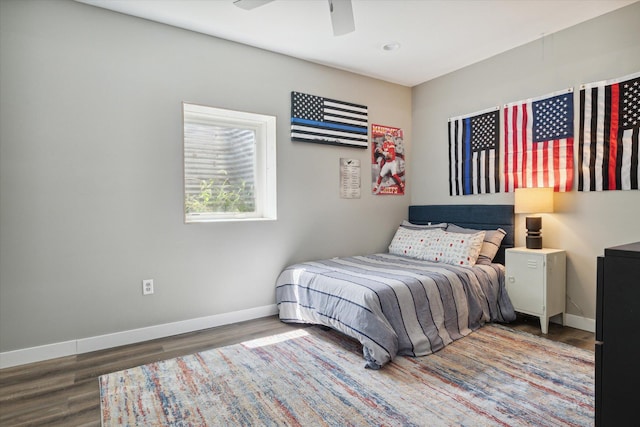 bedroom with dark hardwood / wood-style flooring and ceiling fan