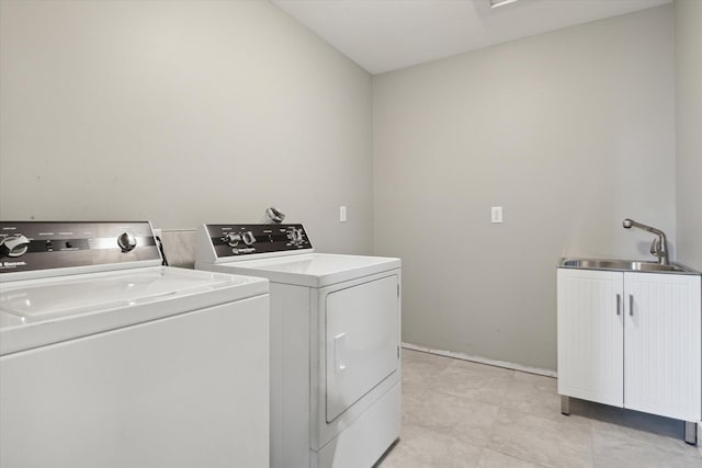 laundry room featuring cabinets, separate washer and dryer, and sink