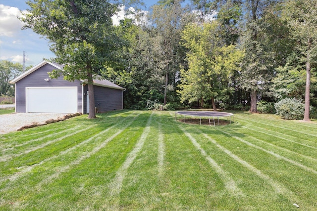 view of yard with an outdoor structure, a garage, and a trampoline