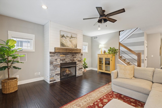 living room with a fireplace, dark hardwood / wood-style flooring, and ceiling fan