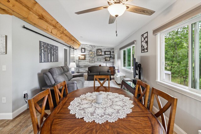8529 N Blair Dr, Bitely, MI 49309 - dining room with an accent wall, baseboards, lofted ceiling, wood finished floors, and ceiling fan