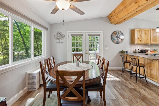 dining room featuring vaulted ceiling with beams, ceiling fan, french doors, and light wood-type flooring