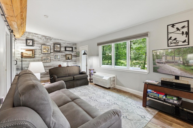 living room featuring wooden walls, light hardwood / wood-style floors, and vaulted ceiling