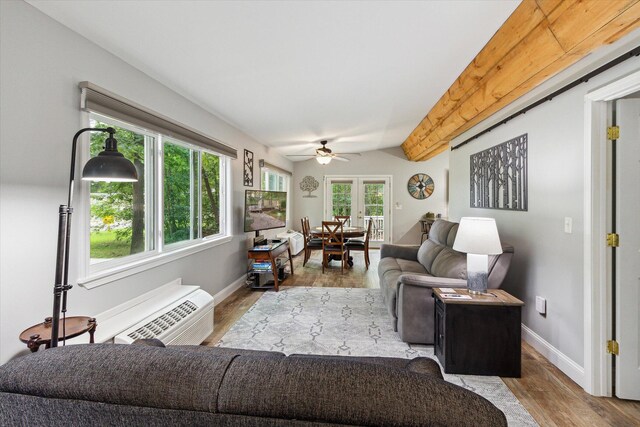 8529 N Blair Dr, Bitely, MI 49309 - living area featuring ceiling fan, wood finished floors, baseboards, a wall unit AC, and lofted ceiling