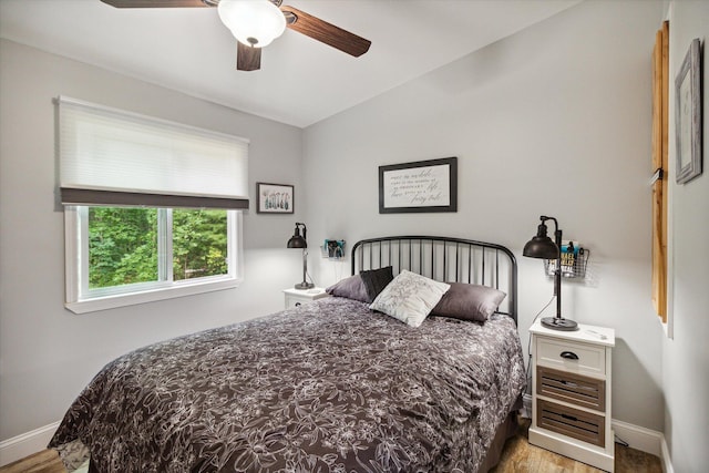 bedroom featuring ceiling fan, light hardwood / wood-style floors, and lofted ceiling