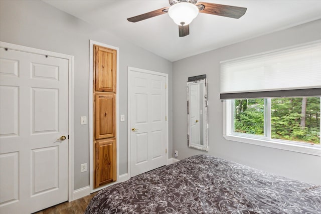 bedroom featuring ceiling fan, dark hardwood / wood-style floors, and vaulted ceiling