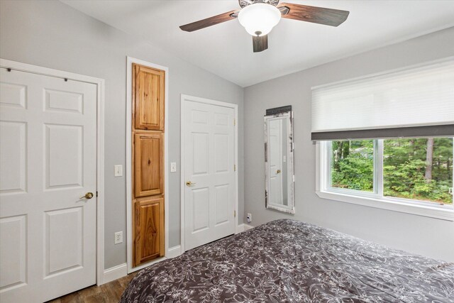 8529 N Blair Dr, Bitely, MI 49309 - unfurnished bedroom featuring lofted ceiling, dark wood-type flooring, ceiling fan, and baseboards