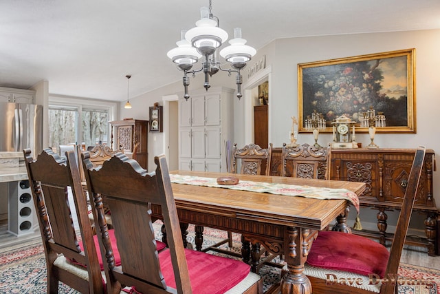 dining area with wood-type flooring, lofted ceiling, and an inviting chandelier