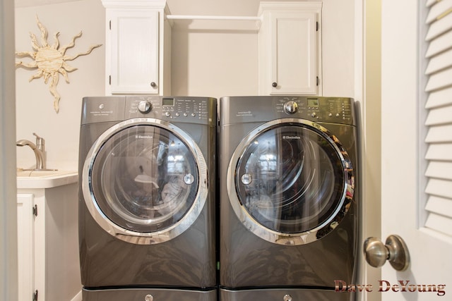 laundry area with cabinets and washing machine and clothes dryer