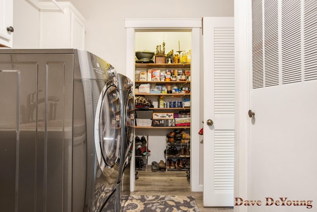 laundry room featuring cabinets, washer and dryer, and wood-type flooring