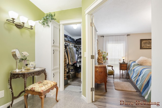 bedroom with light hardwood / wood-style floors, a spacious closet, and a closet