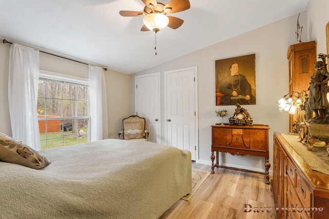 bedroom with ceiling fan, light hardwood / wood-style flooring, and vaulted ceiling