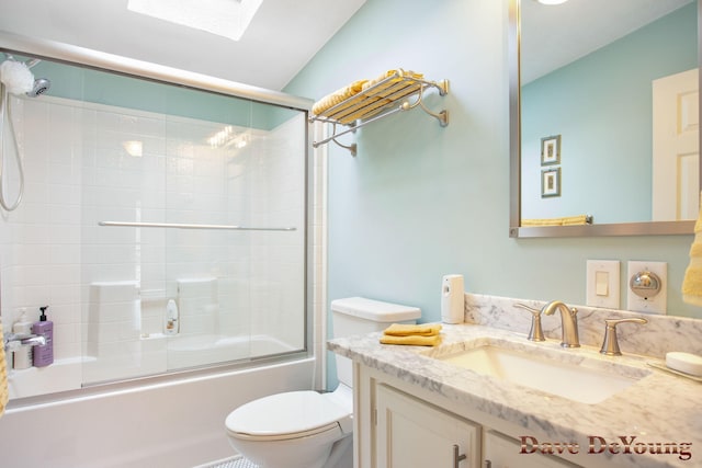 full bathroom with vaulted ceiling with skylight, vanity, bath / shower combo with glass door, and toilet