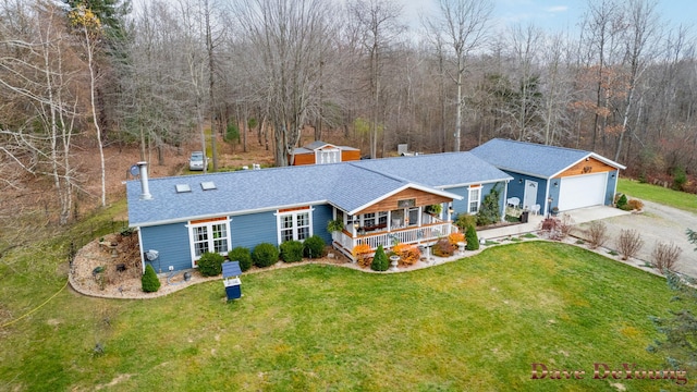 single story home with covered porch, an outbuilding, and a front lawn