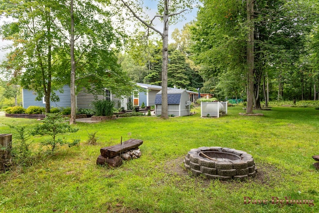 view of yard with a shed and an outdoor fire pit