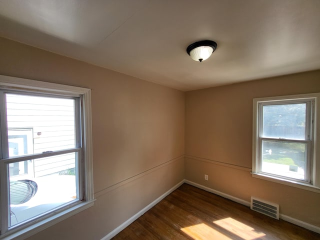 spare room with hardwood / wood-style flooring and a healthy amount of sunlight