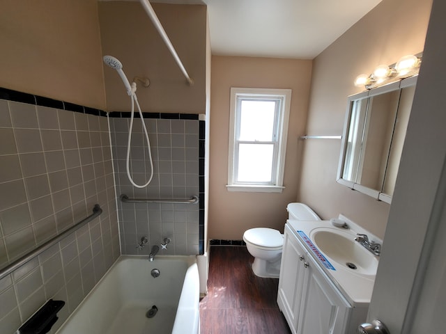 full bathroom with hardwood / wood-style floors, vanity, toilet, and tiled shower / bath