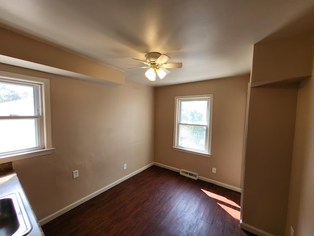 empty room with dark hardwood / wood-style floors and ceiling fan