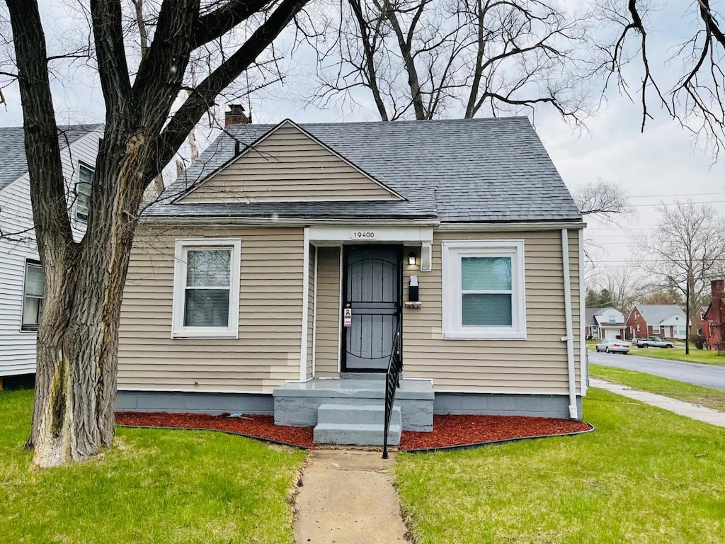 bungalow featuring a front lawn