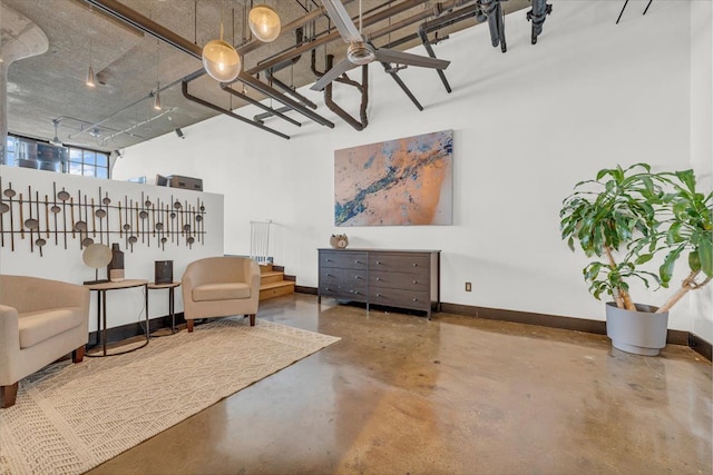 sitting room with a towering ceiling and concrete flooring