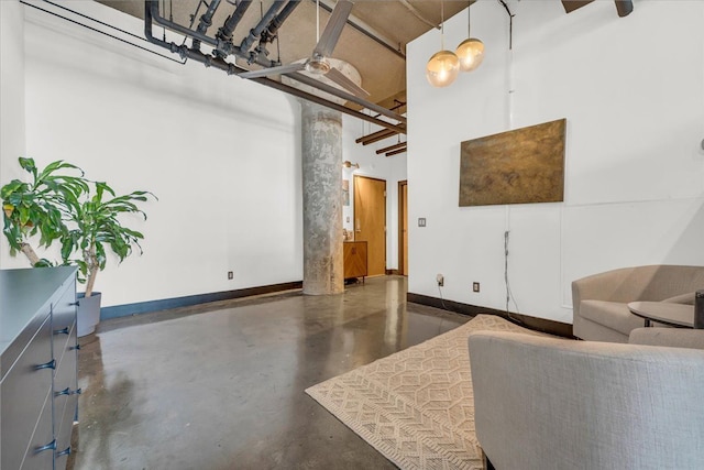 living room featuring ceiling fan and a towering ceiling