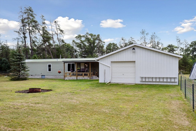 rear view of property with a lawn, covered porch, and a garage