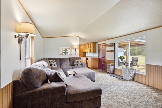 carpeted living room with a textured ceiling, wooden walls, and lofted ceiling