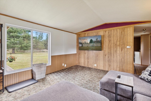 carpeted living room with wood walls, a healthy amount of sunlight, and lofted ceiling