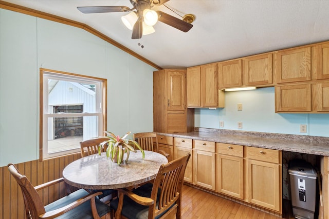 kitchen featuring crown molding, ceiling fan, light hardwood / wood-style floors, and vaulted ceiling