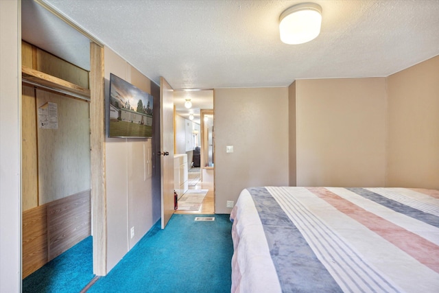 unfurnished bedroom with a textured ceiling, dark carpet, and a closet