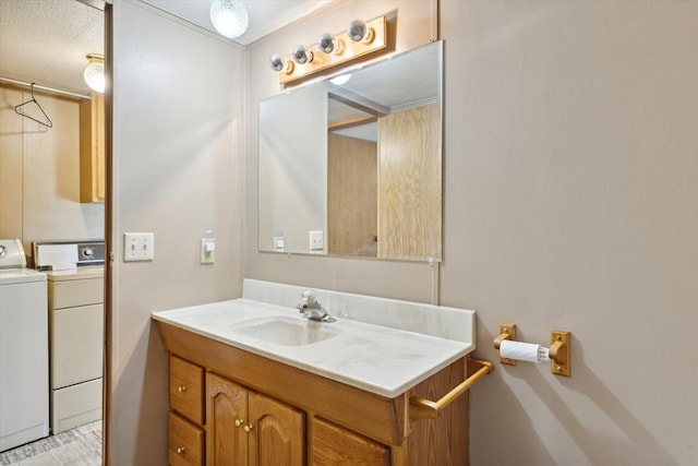 bathroom featuring separate washer and dryer, vanity, and a textured ceiling