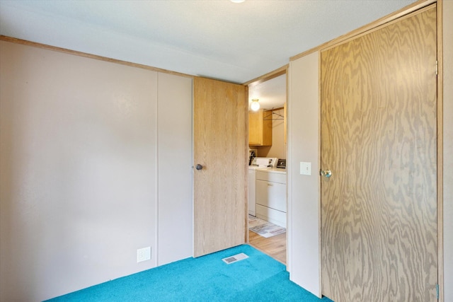 empty room with separate washer and dryer, a textured ceiling, and light wood-type flooring