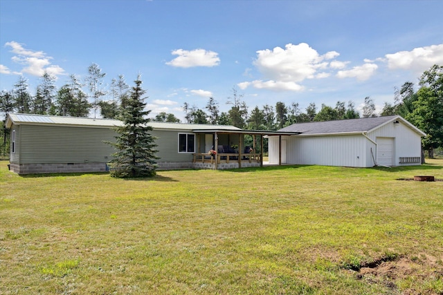 back of property with an outbuilding, a garage, and a lawn