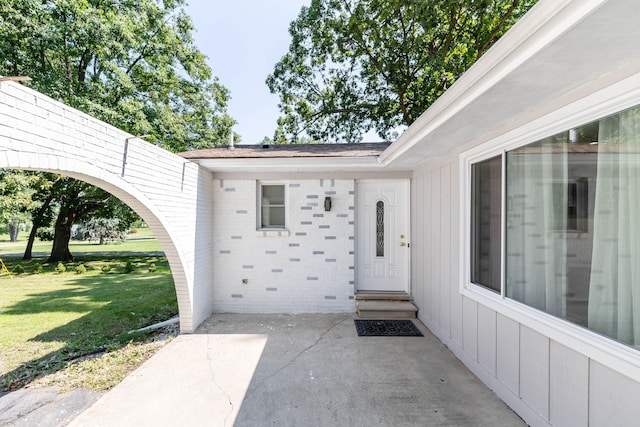 property entrance featuring a yard and a patio