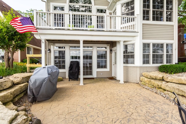 rear view of house featuring a patio area and a balcony