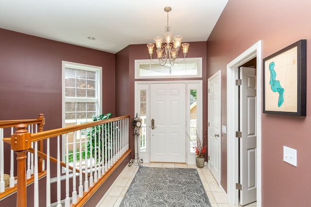 tiled entryway with a chandelier