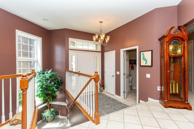 entryway with a wealth of natural light, light tile patterned flooring, and a chandelier