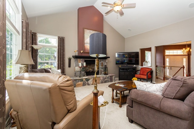 living room with carpet flooring, a fireplace, high vaulted ceiling, and ceiling fan with notable chandelier