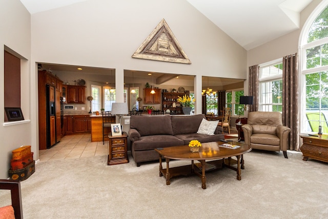 living room featuring light carpet, high vaulted ceiling, and a chandelier