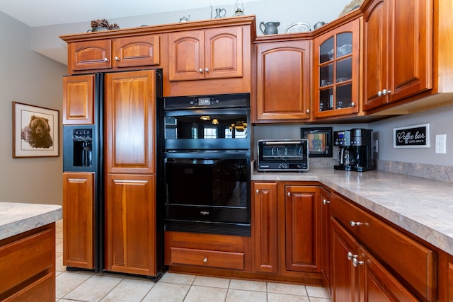 kitchen with paneled built in refrigerator, light tile patterned floors, and double oven