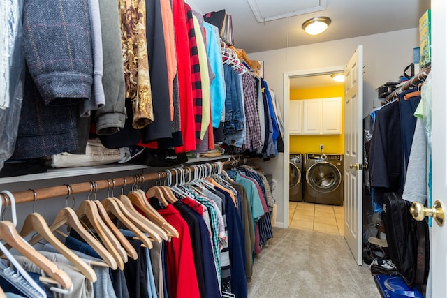 spacious closet with washing machine and dryer and light tile patterned flooring