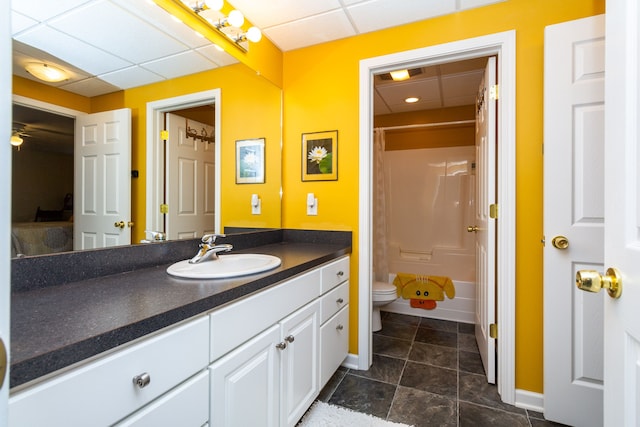 bathroom featuring ceiling fan, a drop ceiling, vanity, and toilet