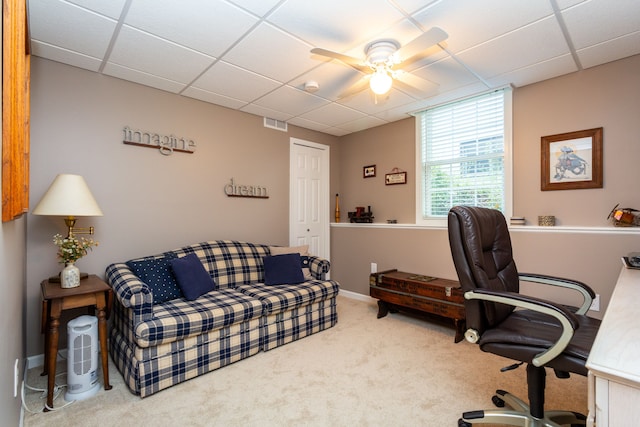 carpeted office with ceiling fan and a drop ceiling