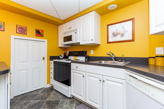 kitchen with white cabinetry, sink, a drop ceiling, and white appliances