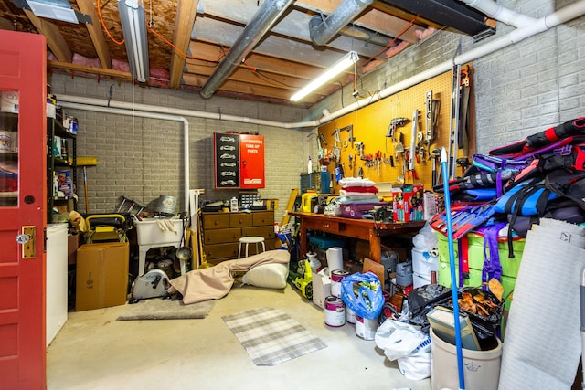 basement with a workshop area and brick wall