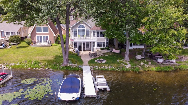 rear view of house with a lawn, a balcony, a water view, and french doors