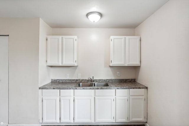 kitchen featuring white cabinetry and sink